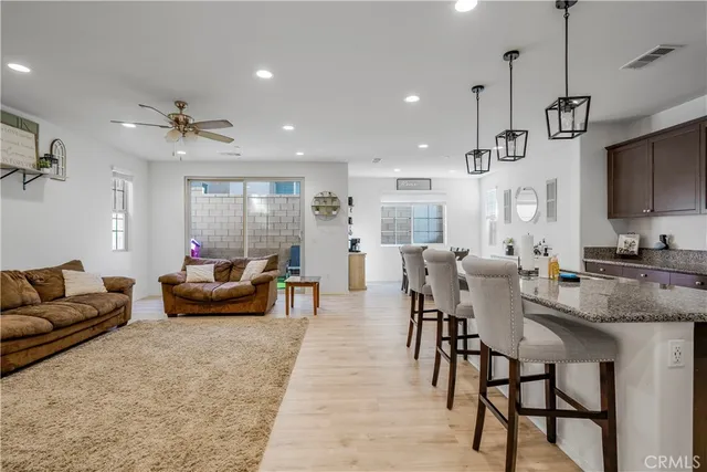 a view of a dining room and livingroom with furniture wooden floor a chandelier