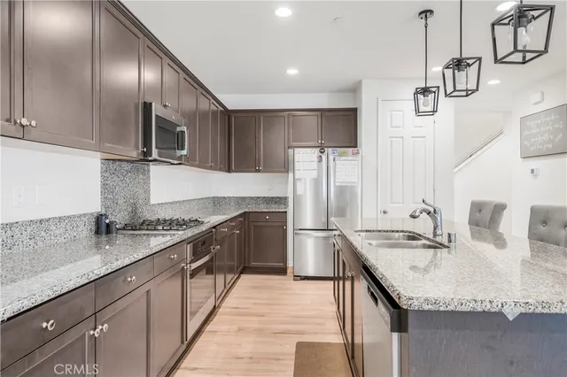 a kitchen with stainless steel appliances granite countertop a sink refrigerator and cabinets