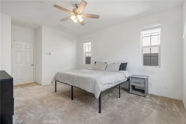 a spacious bedroom with a bed and a window