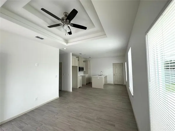 a view of empty room with wooden floor and ceiling fan