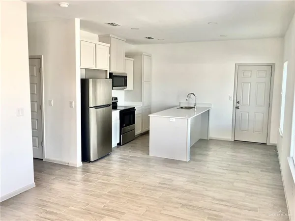 a kitchen with stainless steel appliances a refrigerator sink and cabinets