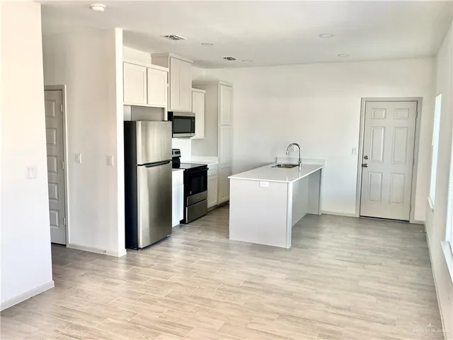 a kitchen with stainless steel appliances a refrigerator sink and cabinets