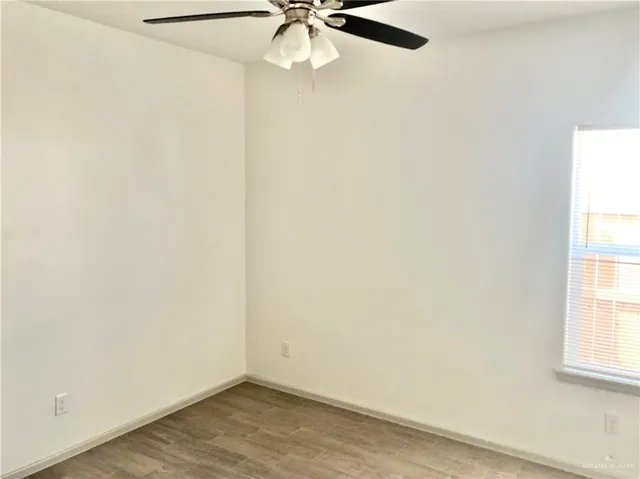 an empty room with a window and a fan