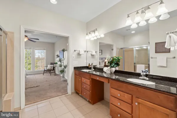 a spacious bathroom with a granite countertop double sink and a mirror