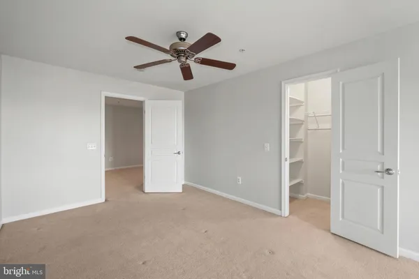 an empty room with fan and windows