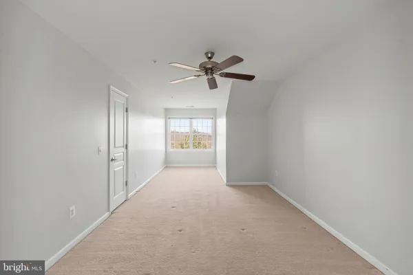 a view of an empty room with a fireplace and a window