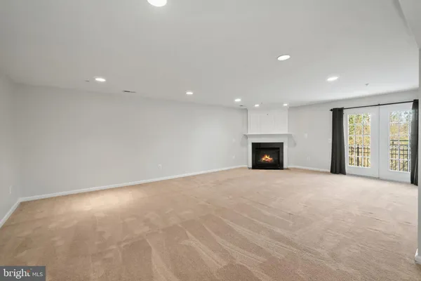 a view of an empty room with a fireplace and a window