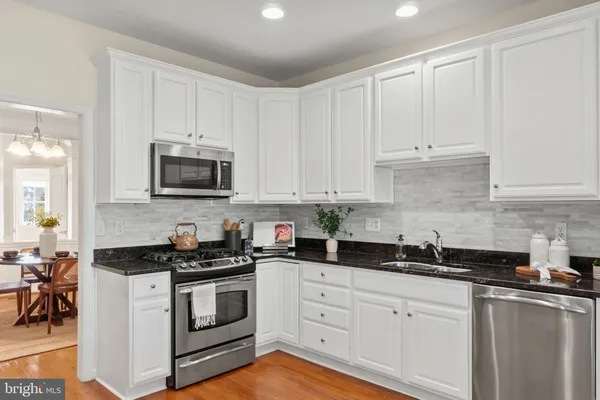 a kitchen with white cabinets and black appliances