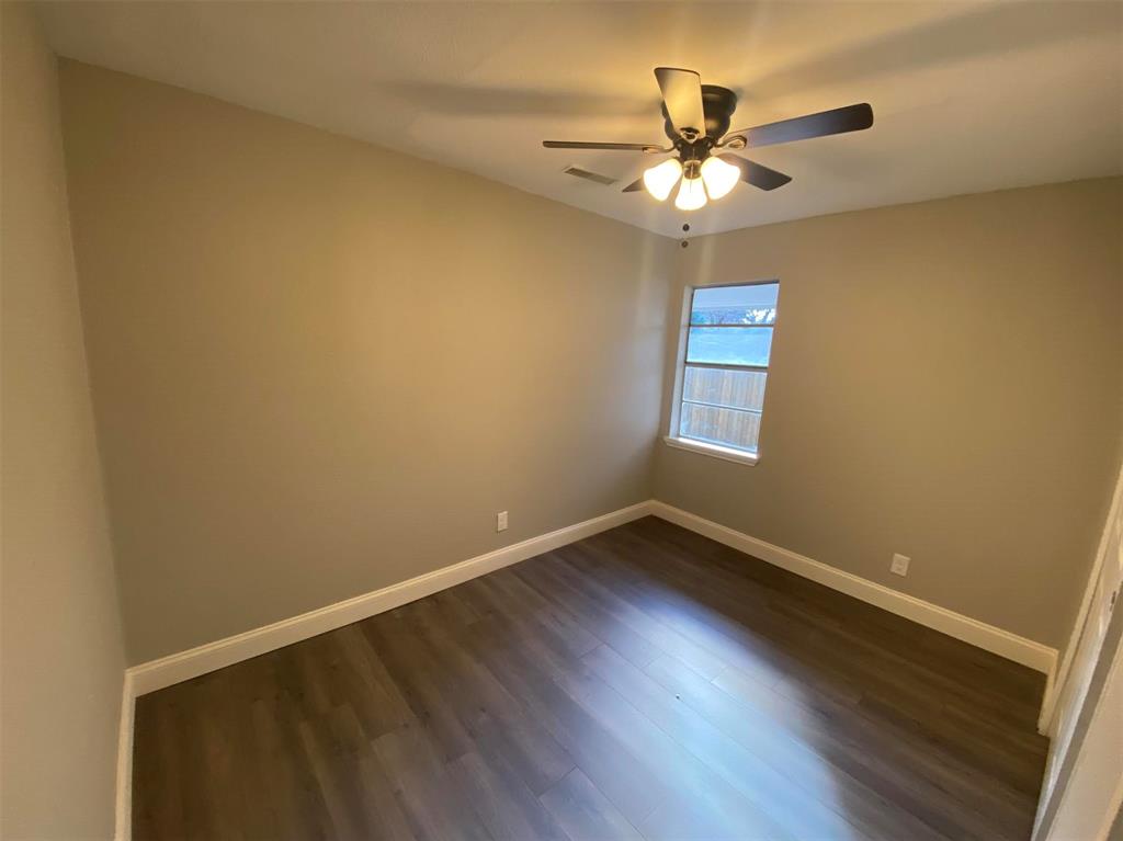 2006 West Northgate Drive Irving, TX 75062 - Photo 12 of 26 an empty room with wooden floor and ceiling fan
