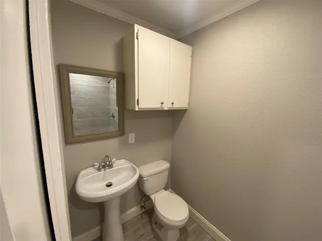 a bathroom with a toilet a sink and mirror