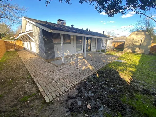 a view of a house with backyard and sitting area