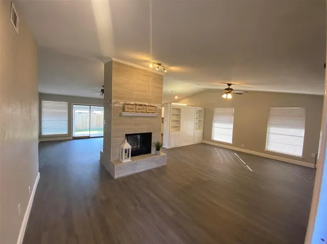a view of empty room with wooden floor and fireplace