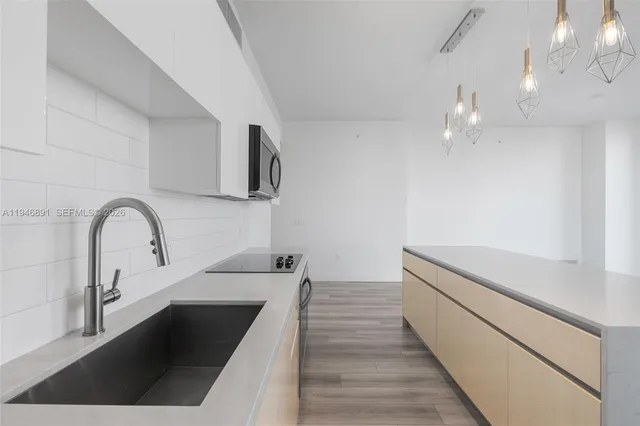 a large kitchen with a large window and stainless steel appliances