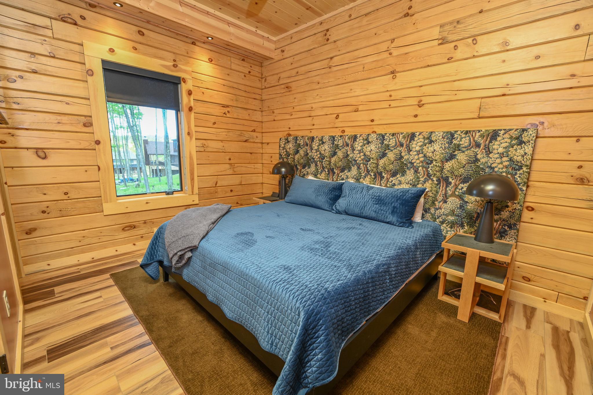 1067 North Camp Road McHenry, MD 21541 - Photo 41 of 81 a bed sitting in a bedroom next to a brick wall