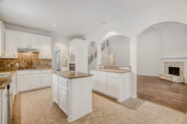 a kitchen with white cabinets and sink