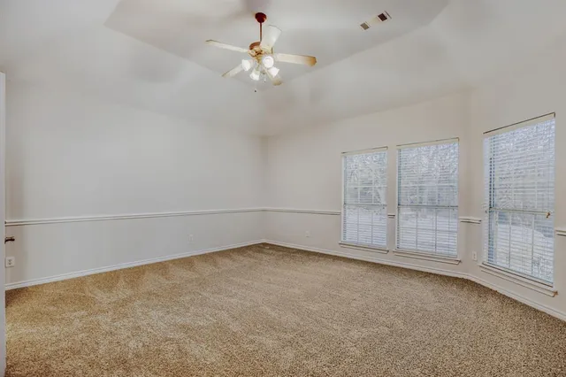 an empty room with chandelier fan