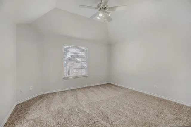 an empty room with a fan & a window