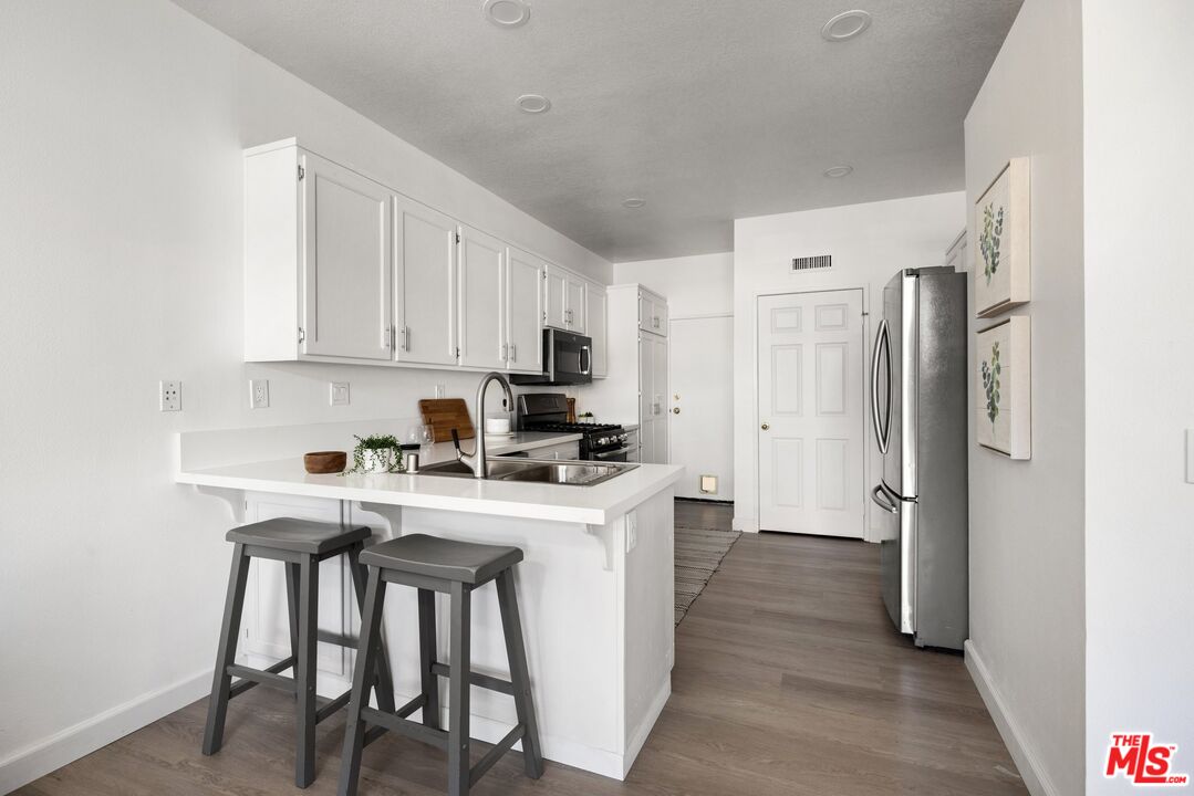 4140 Brookcrest Court Moorpark, CA 93021 - Photo 8 of 27 a kitchen with a table chairs refrigerator and cabinets