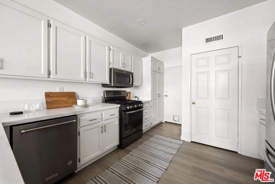 4140 Brookcrest Court Moorpark, CA 93021 - Photo 9 of 27 a kitchen with cabinets stainless steel appliances a sink and wooden floor