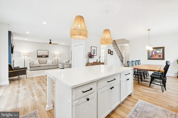 a kitchen with stainless steel appliances granite countertop a table chairs and a wooden floor