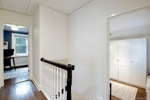 a view of a livingroom with wooden floor and a hallway