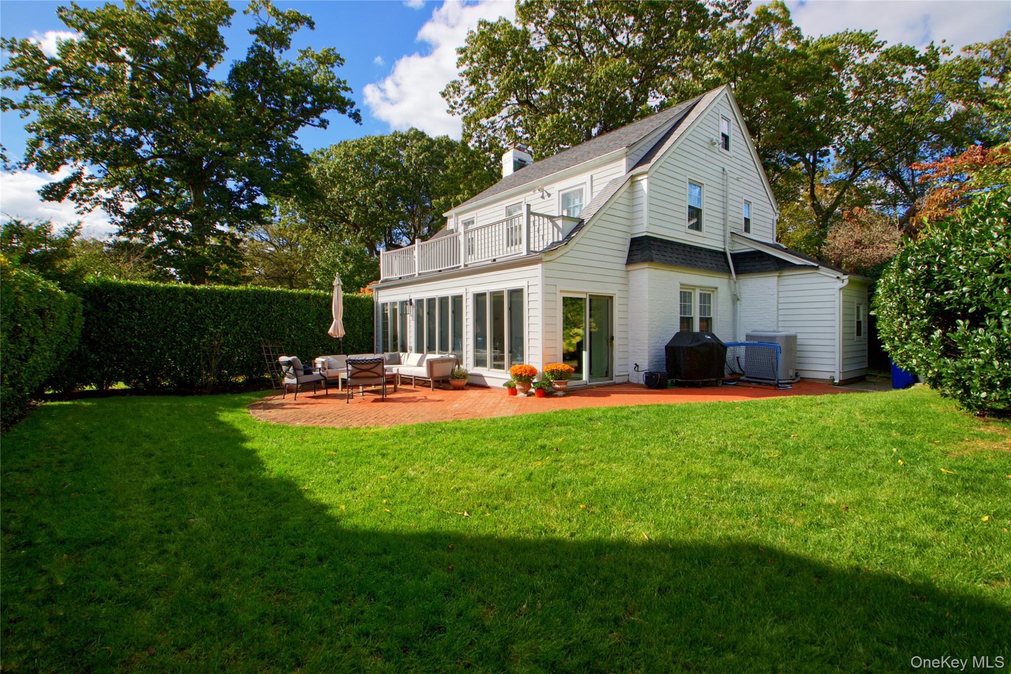 60 Thayer Road Manhasset, NY 11030 - Photo 25 of 28 a front view of a house with swimming pool having outdoor seating