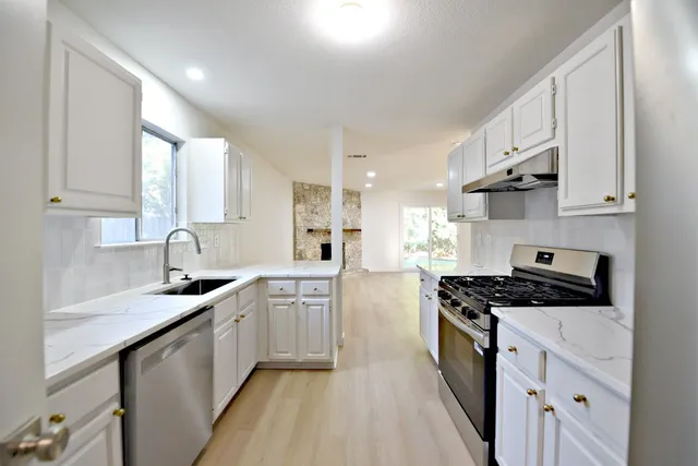a kitchen with stainless steel appliances a sink stove and cabinets