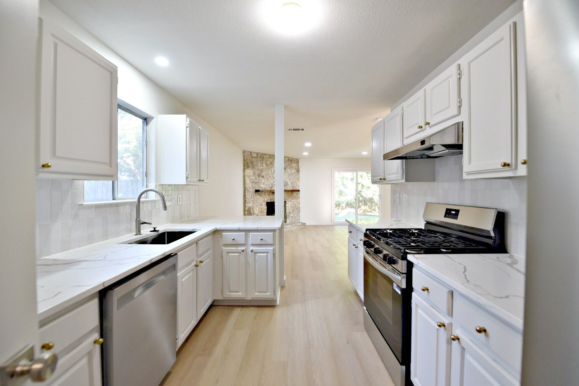 4617 Sidereal Drive Austin, TX 78727 - Photo 12 of 23 a kitchen with stainless steel appliances a sink stove and cabinets