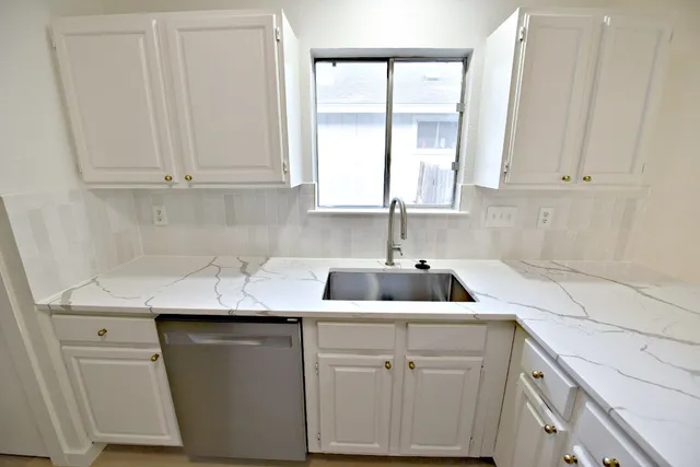 a kitchen with white cabinets and a sink