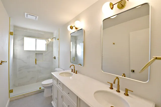 a bathroom with a sink a toilet and shower