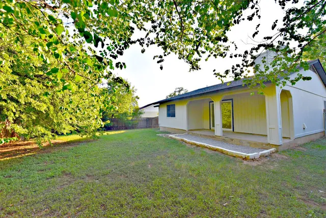 a view of a yard in front of a house with large tree