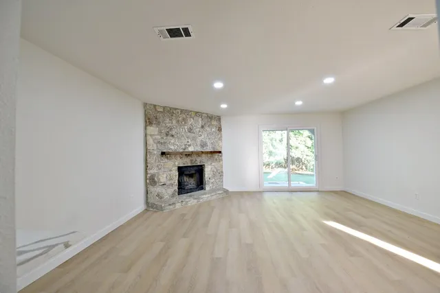 a view of empty room with wooden floor and fireplace