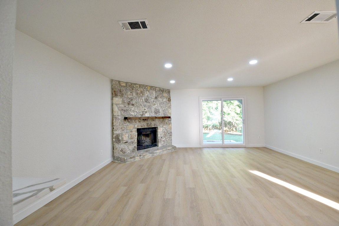 4617 Sidereal Drive Austin, TX 78727 - Photo 7 of 23 a view of empty room with wooden floor and fireplace