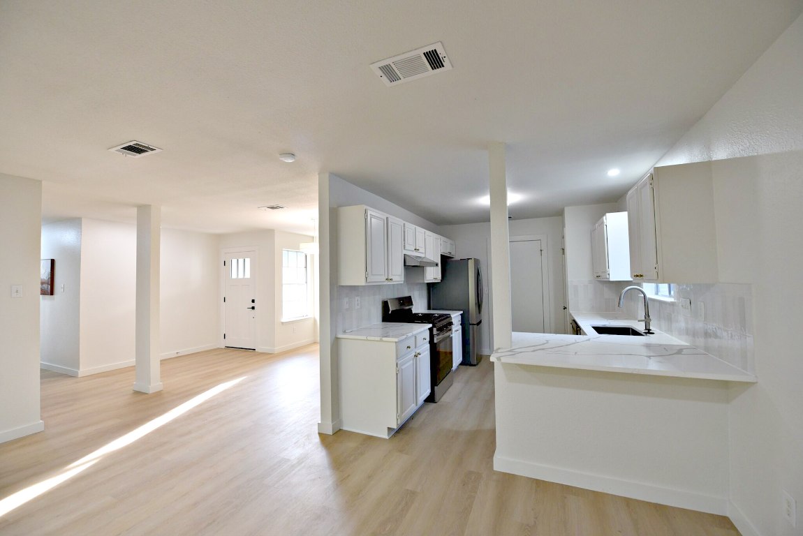 4617 Sidereal Drive Austin, TX 78727 - Photo 9 of 23 a large kitchen with a counter space a sink and stainless steel appliances