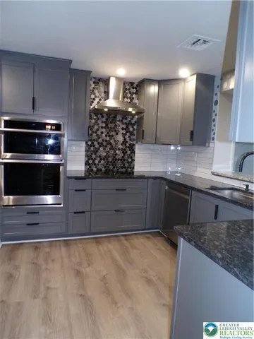 a kitchen with stainless steel appliances granite countertop a stove a sink and a microwave