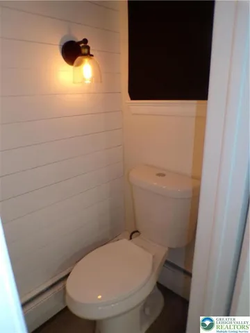 a bathroom with a toilet and a picture