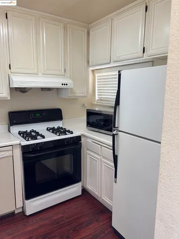 a kitchen with cabinets and white stainless steel appliances