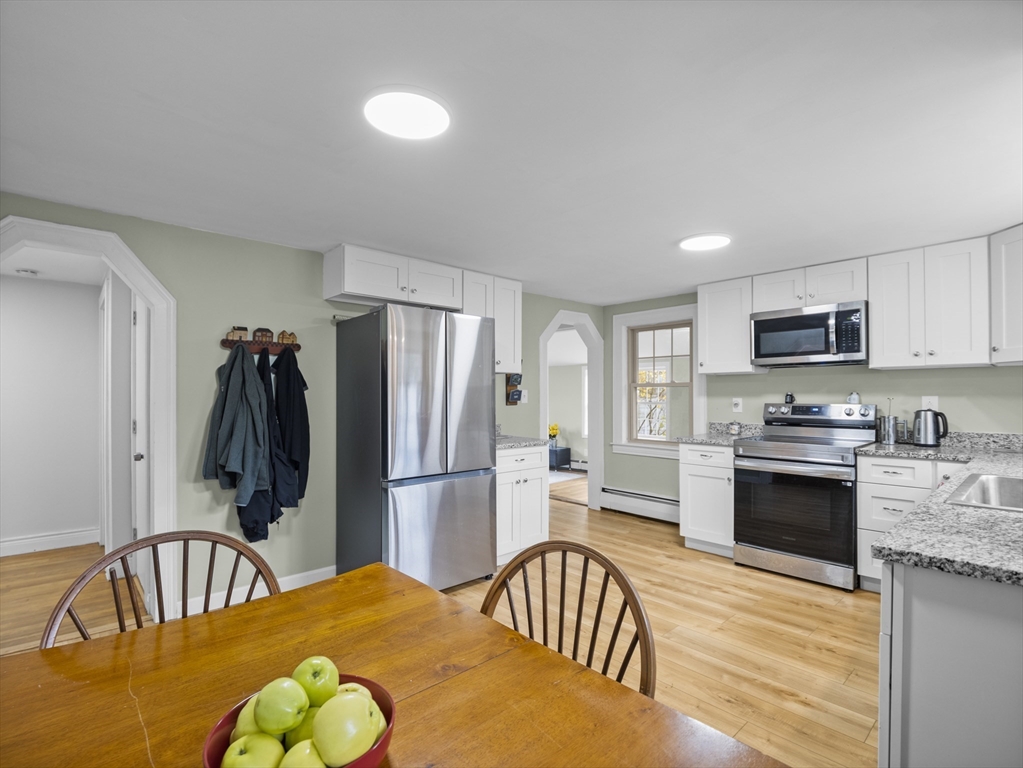 354 Townsend Road Groton, MA 01450 - Photo 20 of 39 a kitchen with stainless steel appliances granite countertop a refrigerator a stove top oven a sink dishwasher and white cabinets with wooden floor