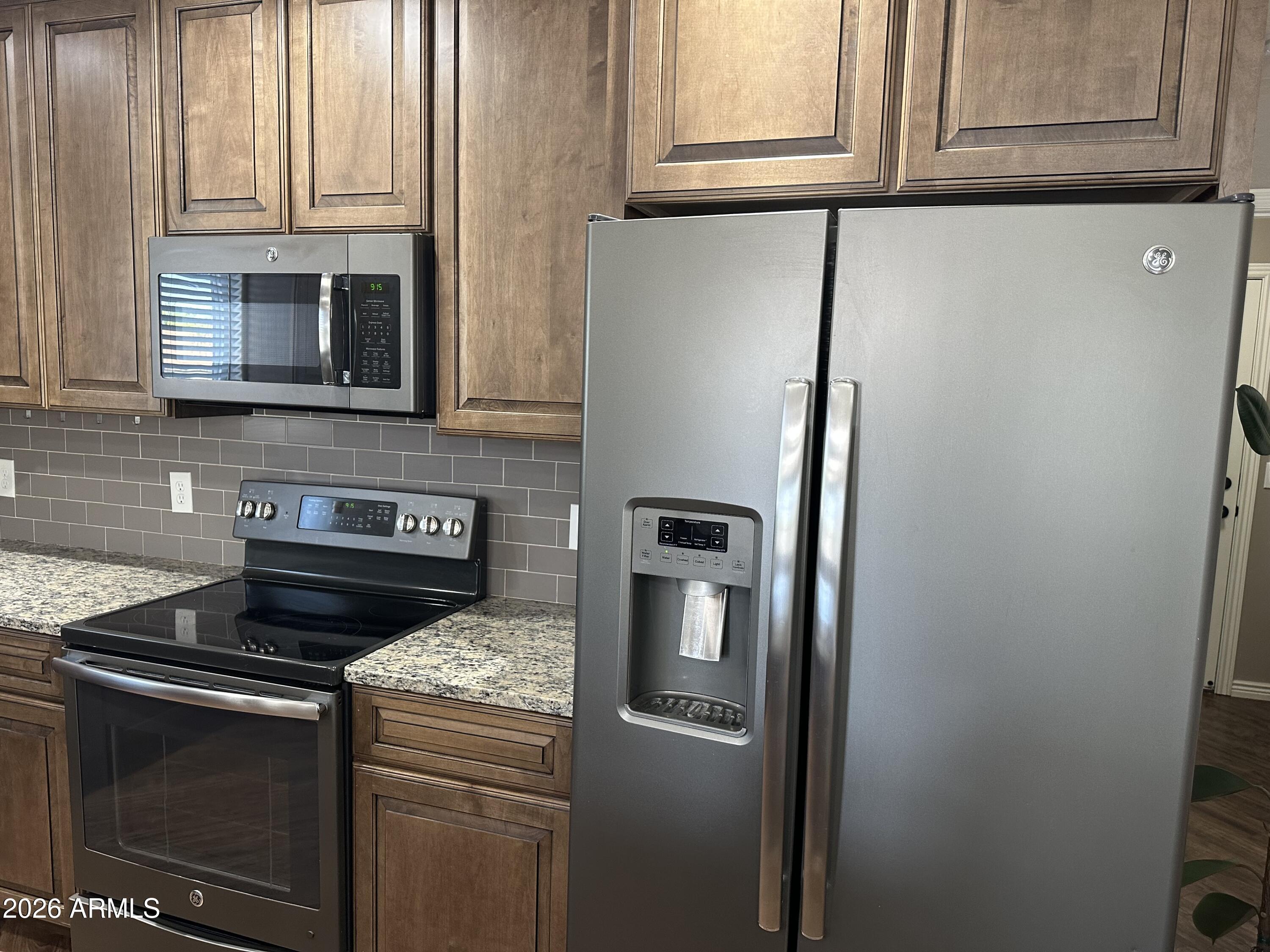1059 West 5th Avenue Apache Junction, AZ 85120 - Photo 12 of 14 a kitchen with granite countertop cabinets and steel stainless steel appliances