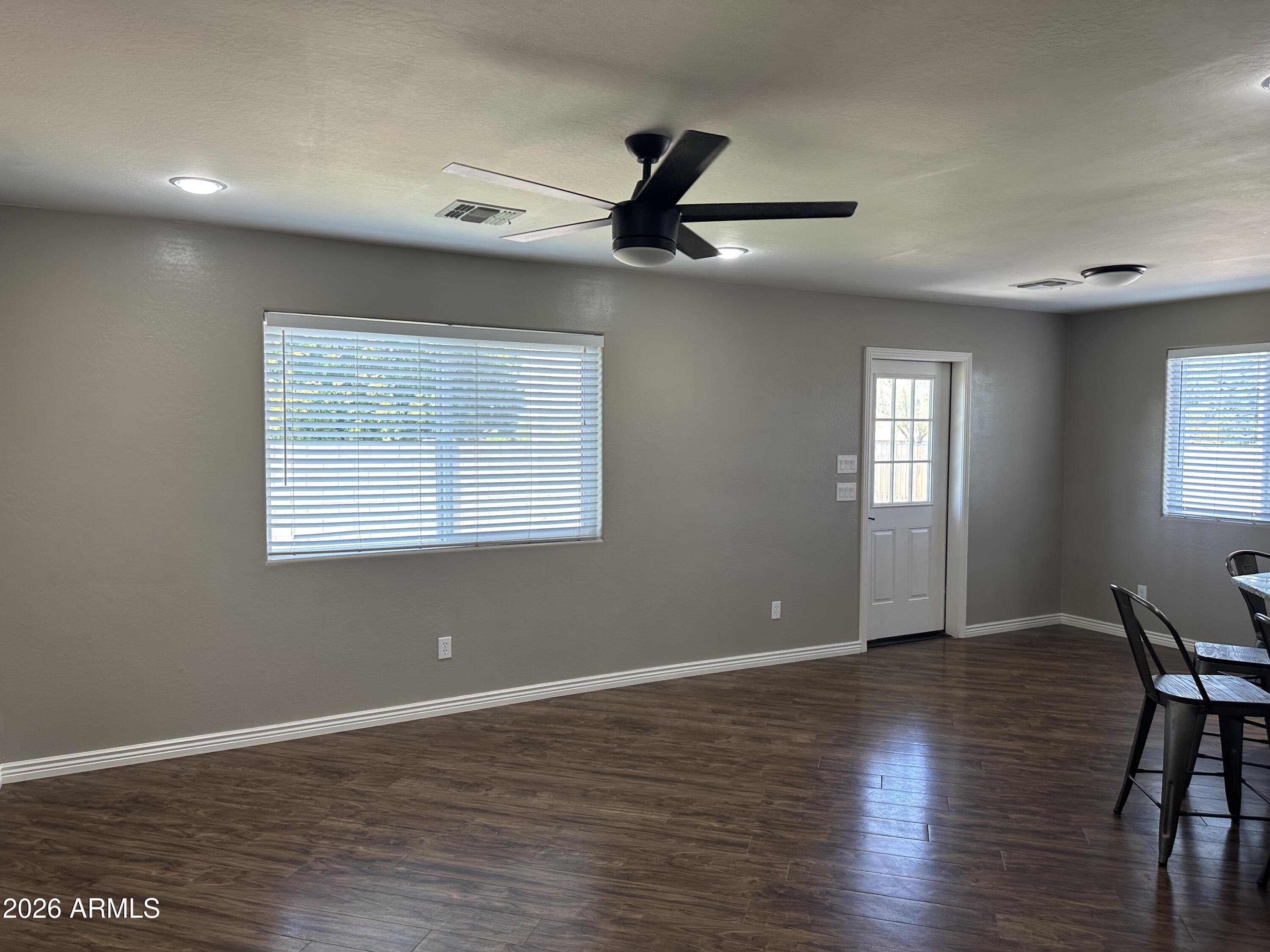 1059 West 5th Avenue Apache Junction, AZ 85120 - Photo 3 of 14 a view of an empty room with wooden floor and a window