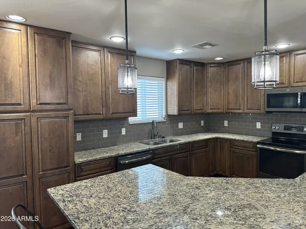 a kitchen with kitchen island granite countertop a sink window and cabinets