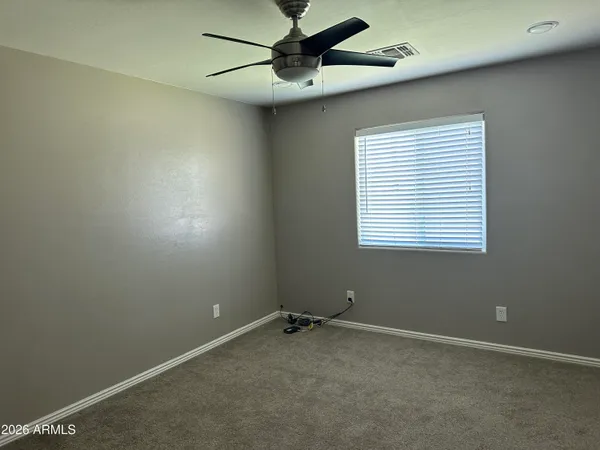 a view of a room with a ceiling fan and a window
