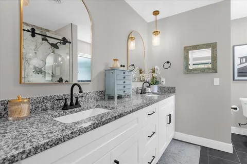 a bathroom with double vanity sinks a vanity two mirror and shower