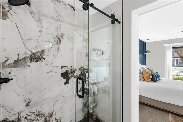 a bath room with a bed and a glass door