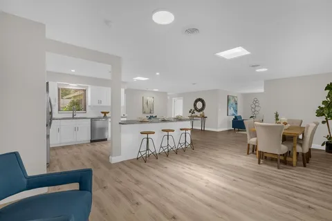 a living room with furniture and view of kitchen