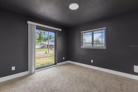 an empty room with windows and closet