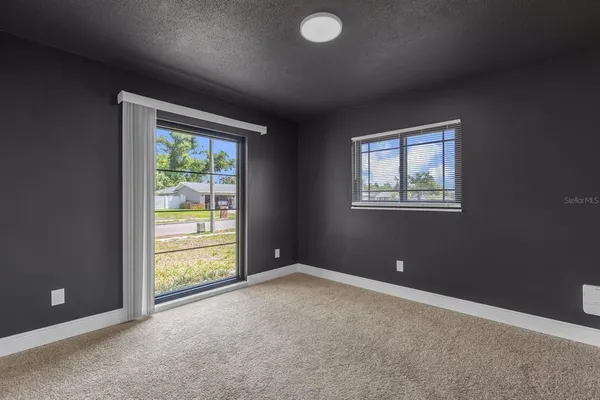 an empty room with windows and closet