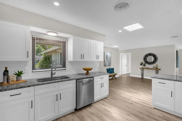 a kitchen with a sink cabinets and wooden floor