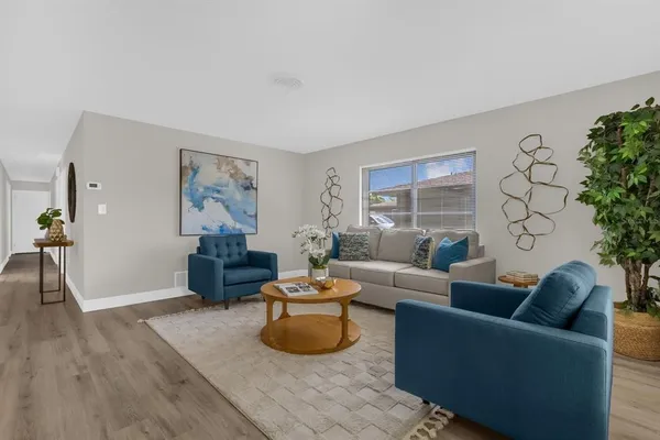 a living room with furniture and a wooden floor