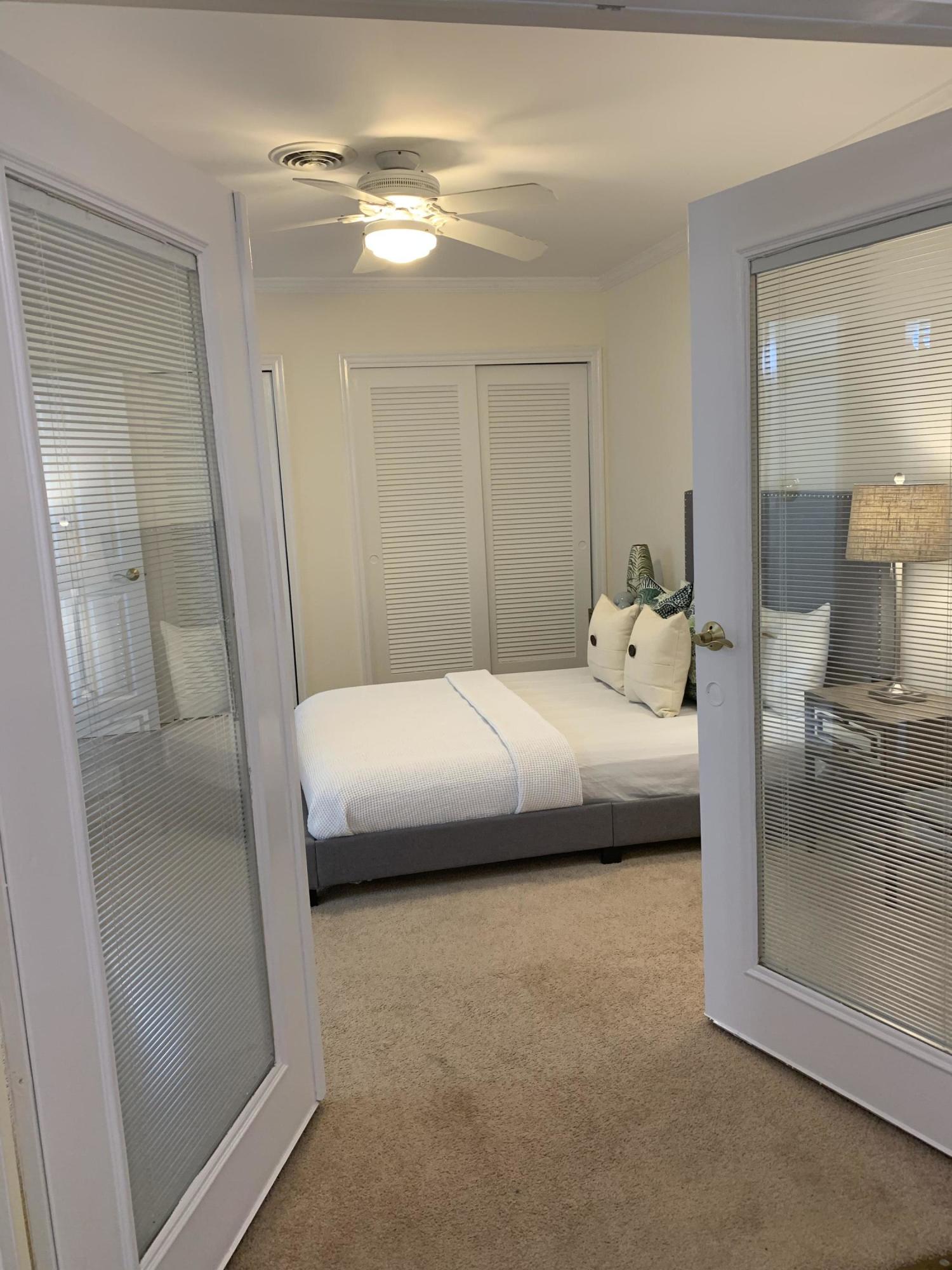 770 East Camino Real, Unit 60 Boca Raton, FL 33432 - Photo 17 of 40 a bedroom with a bed and a mirror